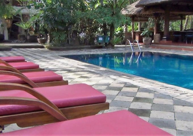 The pool features a stone deck with colorful lounge chairs.