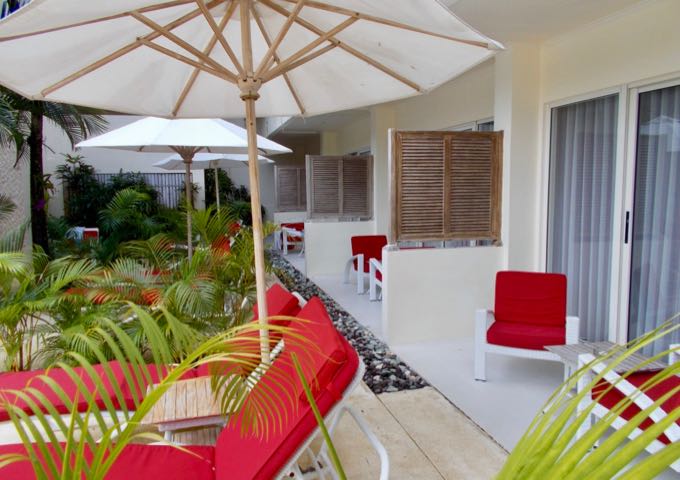 The rooms are colorful, and lounge chairs are placed in front of the ground-level patios.