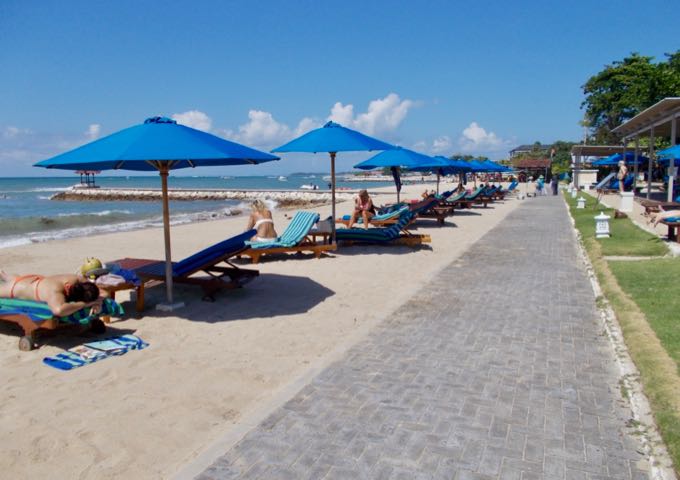 The resort beach features white sand, blue water, and a lovely path.