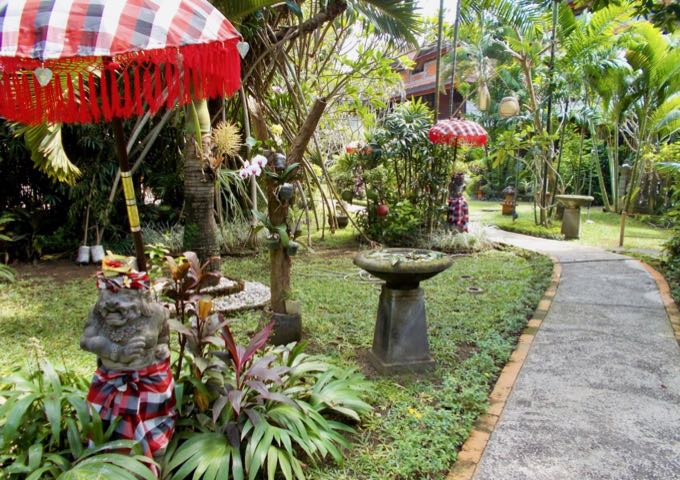 The hotel features several Balinese statues and stone vases in its gardens.