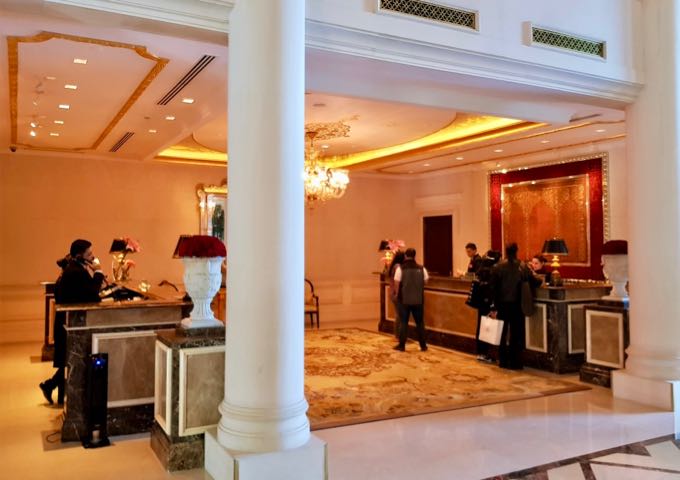 The reception features marble columns and plush rugs.