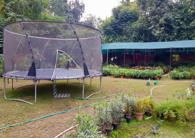 The large garden features a trampoline.