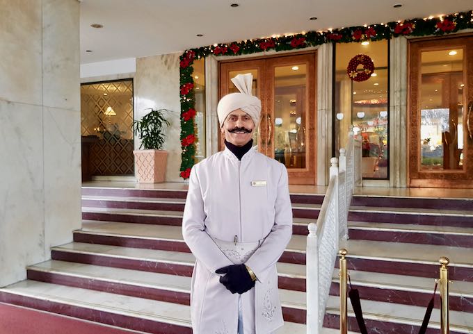 The regal hotel features a traditionally-dressed doorman at the entrance.
