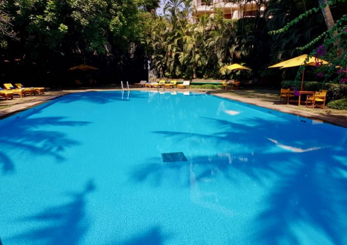 The large, sparkling blue pool offers plenty of natural shade.