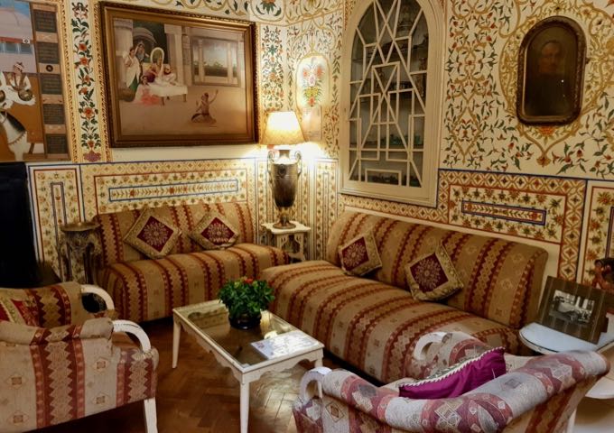 The guest lounge features old-style furniture and prints/photos of old India.