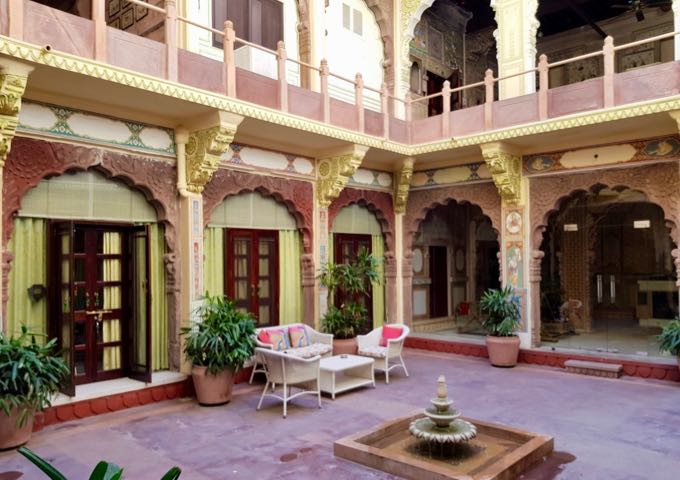 The inner courtyard features fountains, guest lounges, and galleries.