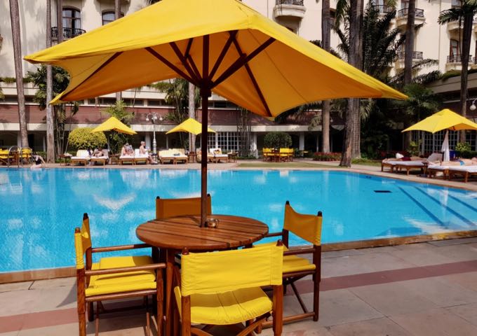 The large pool offers a tropical island vibe with its palm trees and colorful seating.