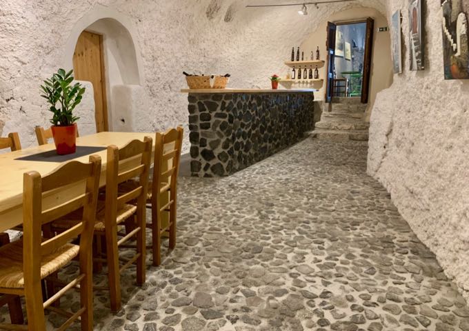 Tables and wine for purchase in Art Space Santorini wine cave