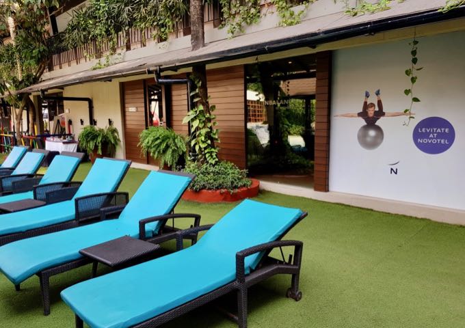 The gym is located in a building by the pool.