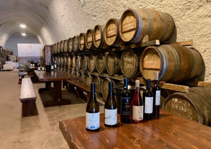 wine bottles set up for wine tasting in a cavernous tasting room