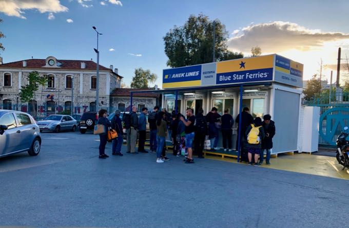 Travelers in a queue for a ferry ticket booth