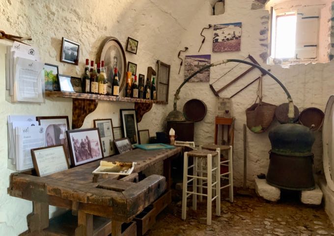 Wooden desk and chair surrounded by old photos and winemaking tools