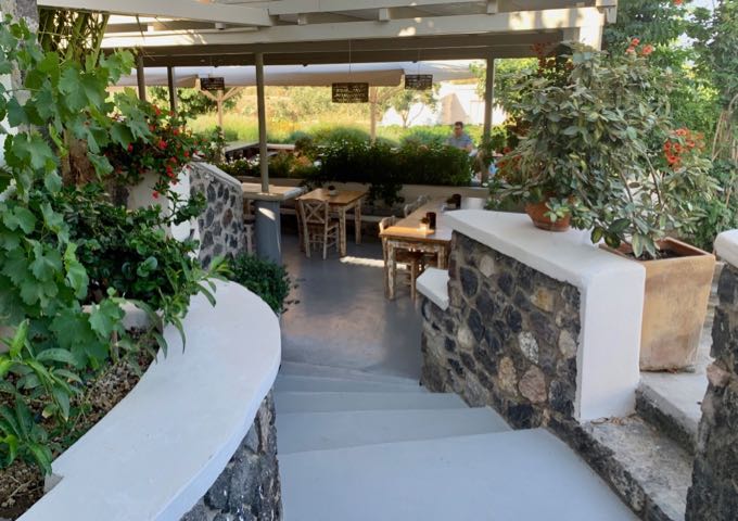 Stairs leading down to a patio with tables set for wine tasting