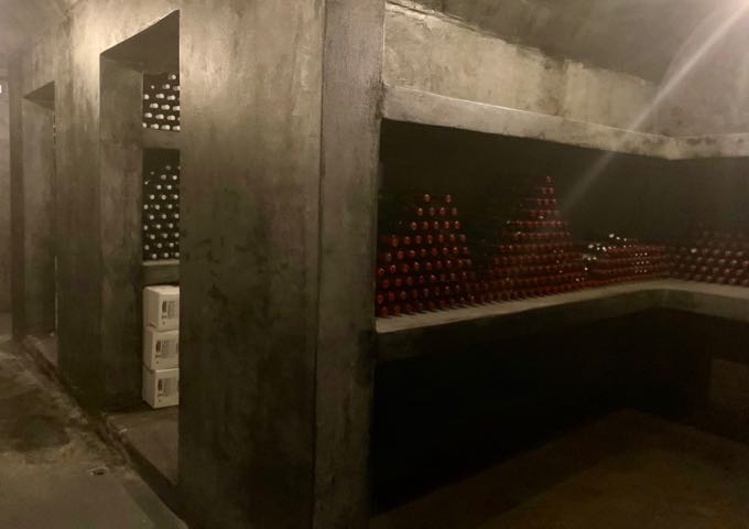 Wine storage area with bottles stacked in their side in pyramid formation
