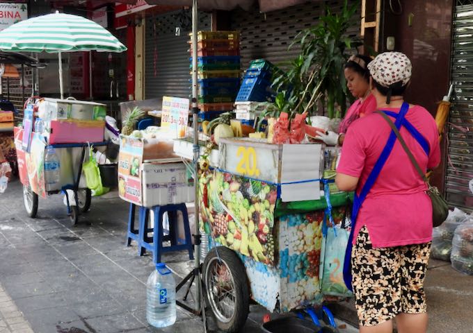 There are several street vendors selling food and drinks in the neighborhood.