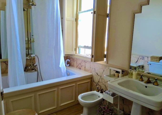 The suite's bathroom features original rose-colored marble.