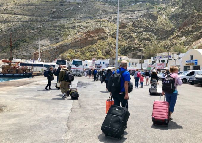 A crowd of tourists navigating the Santorini ferry port.