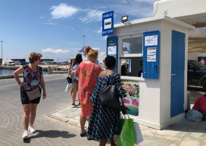 Ticket kiosk at Mykonos Old Port, with passengers waiting in line.