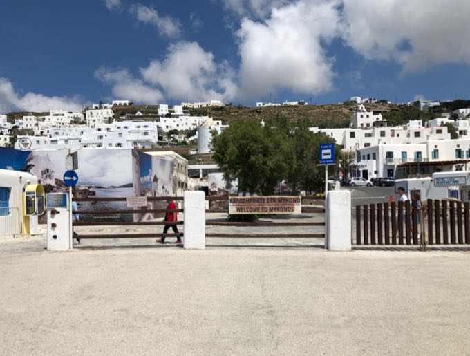 View as you disembark a ferry at Mykonos Old port, with a sign indicatating that a bus stop is nearby.
