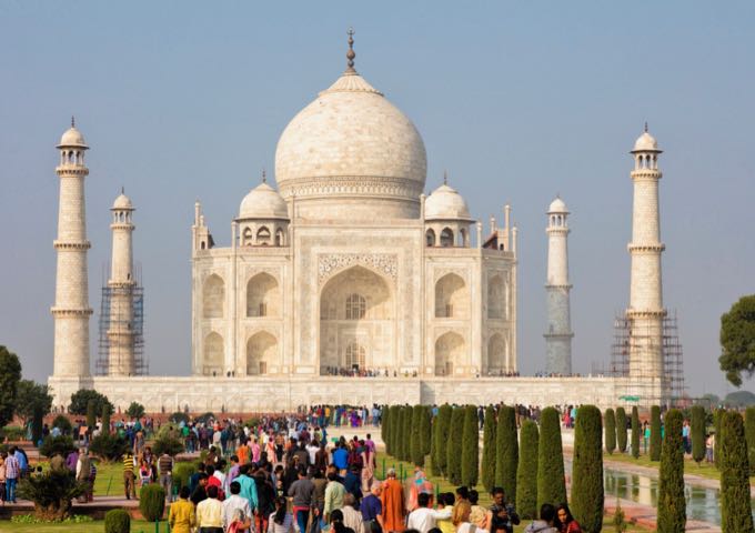 The Taj Mahal with a large crowd of tourists in front of it.