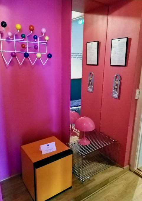 A candy pink hallway connects the orange lounge to the blue bedroom.