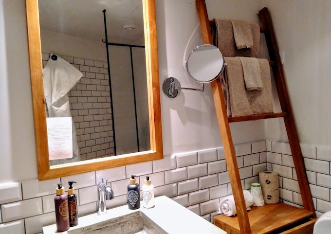 All bathrooms feature white tiles and wooden fixtures.