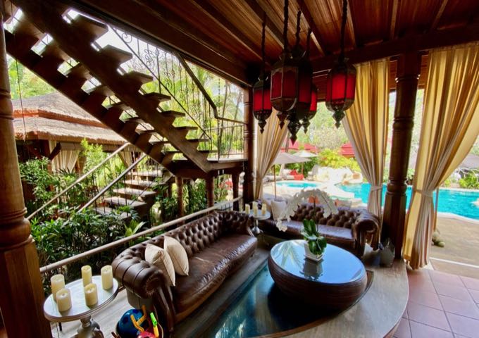 Leather sofa in a covered patio next to a sparkling swimming pool