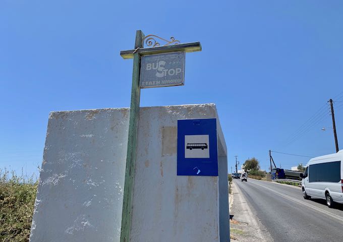 A bus stop in Santorini with two signs.