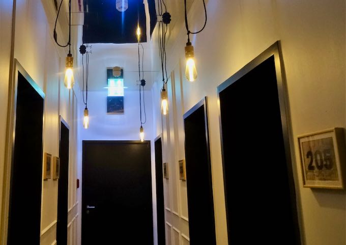 Corridors feature mirrored ceilings and bare bulbs.