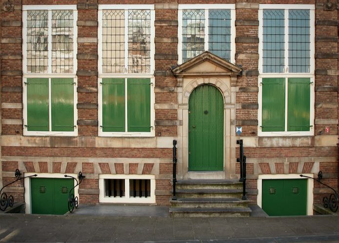 Brick facade with green doors at the Rembrandt House museum in Amsterdam