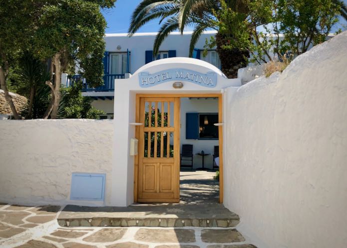 Open wooden gate and sign of Matina Hotel in Mykonos Town