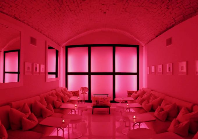 The lounge has an all-white space with colored lighting.