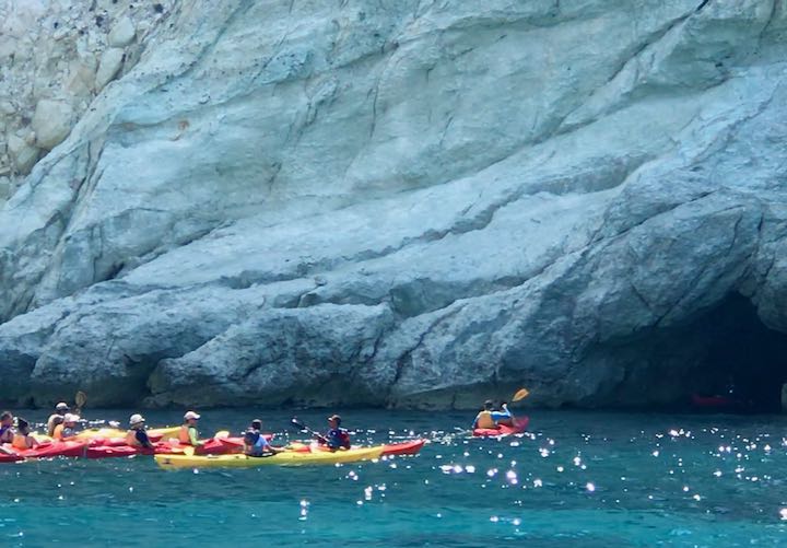 A tour group kayaks in the Santorini caldera