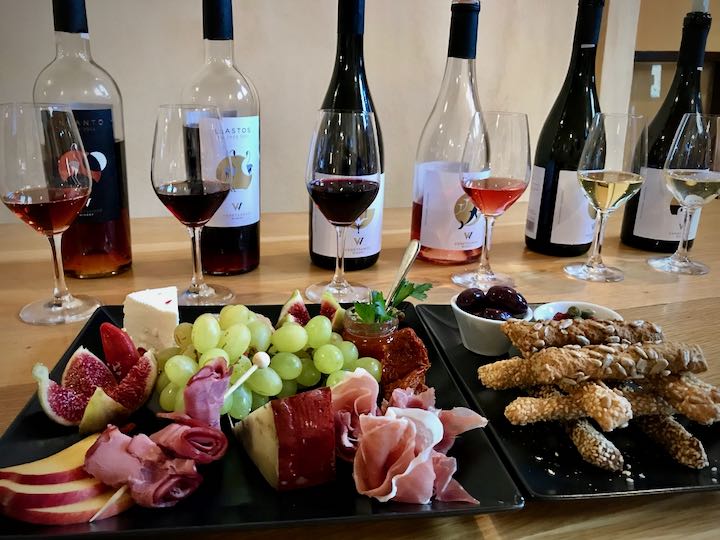 wines lined up for tasting, and a tray of appetizers at a winery tour