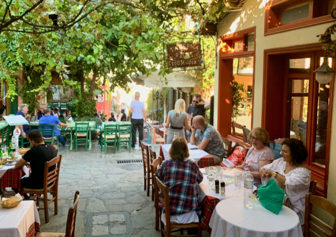diners eat alfresco at cafe tables in a cobblestone courtyard