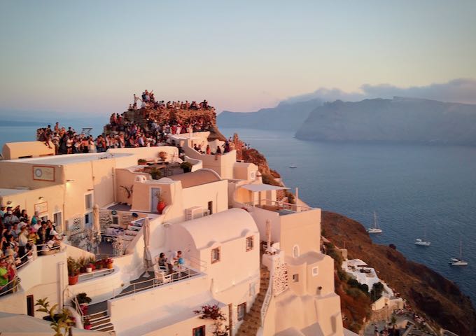 A crowd gathers to watch the sunset at the clifftop town of Oia, Santorini