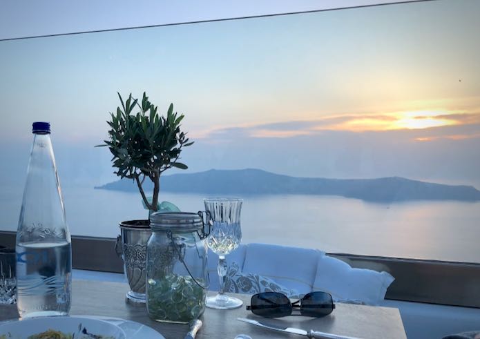 a table set with a view out to the Santorini Caldera
