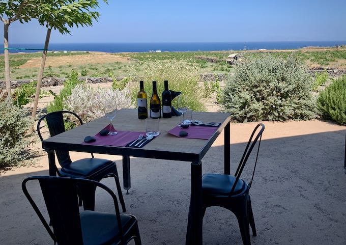 Table set for wine tasting, with a view of the distant sea