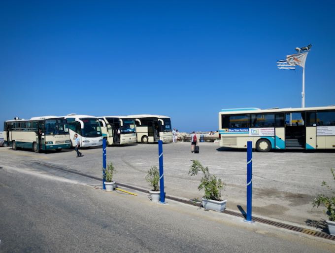 Buses wait at a waterfront ferry terminal