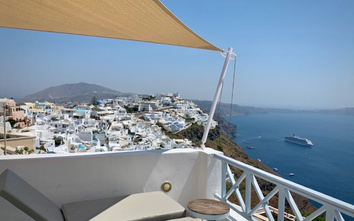 View from a hotel terrace looking down over the town of Fira, Santorini, and the Aegean Sea