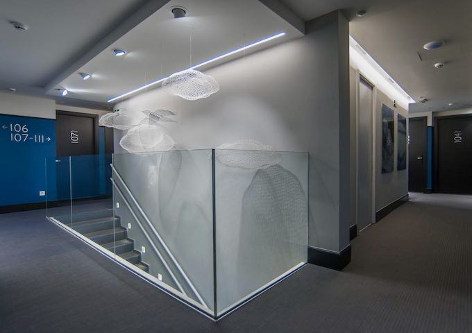Staircases have hanging cloud sculptures.