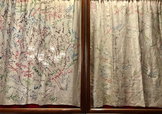 Signed tablecloths hang from the walls.