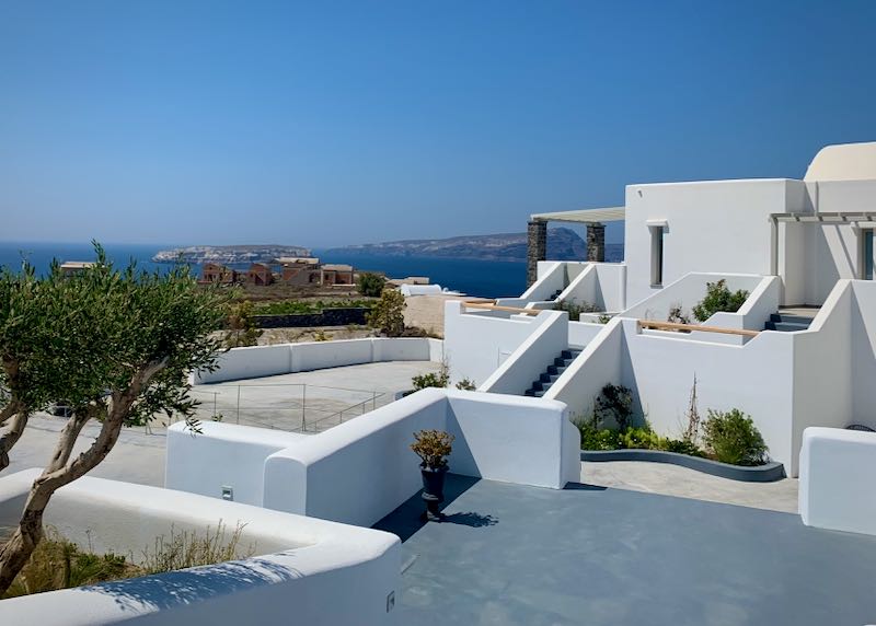 White, Cycladic-style hotel courtyard overlooking the Santorini caldera