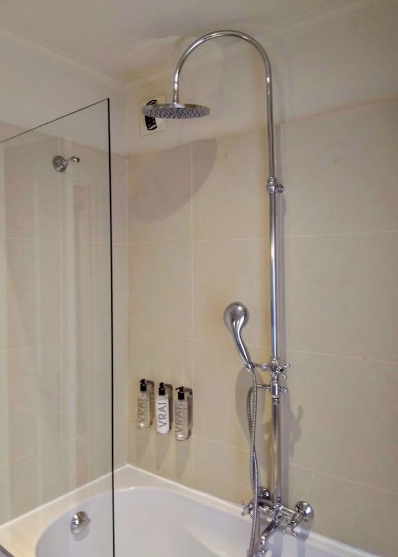 The bathroom has a tub and shower combo.