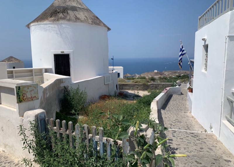 Windmill just outside Rooftop patio with water view at Elinikon restaurant in Oia Santorini