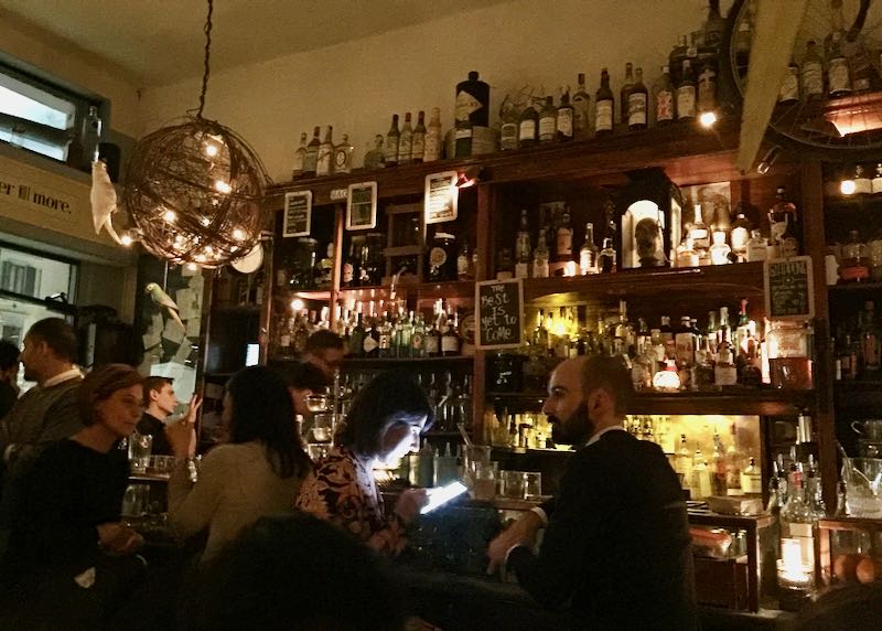 Dimly-lit bar with shelves lined with photos and decor