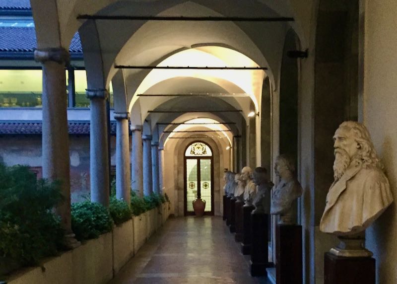 Arched corridor lined with roman columns and marble busts
