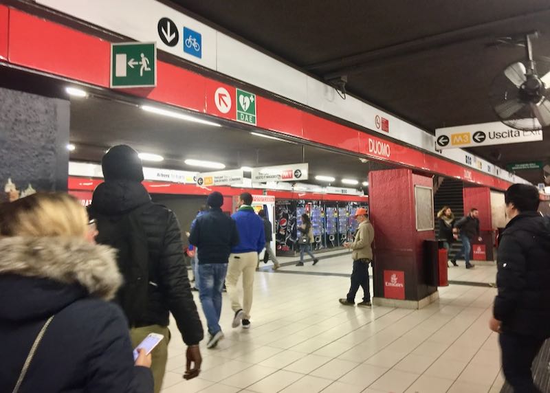 Passengers await a metro train in Milan's Duomo station