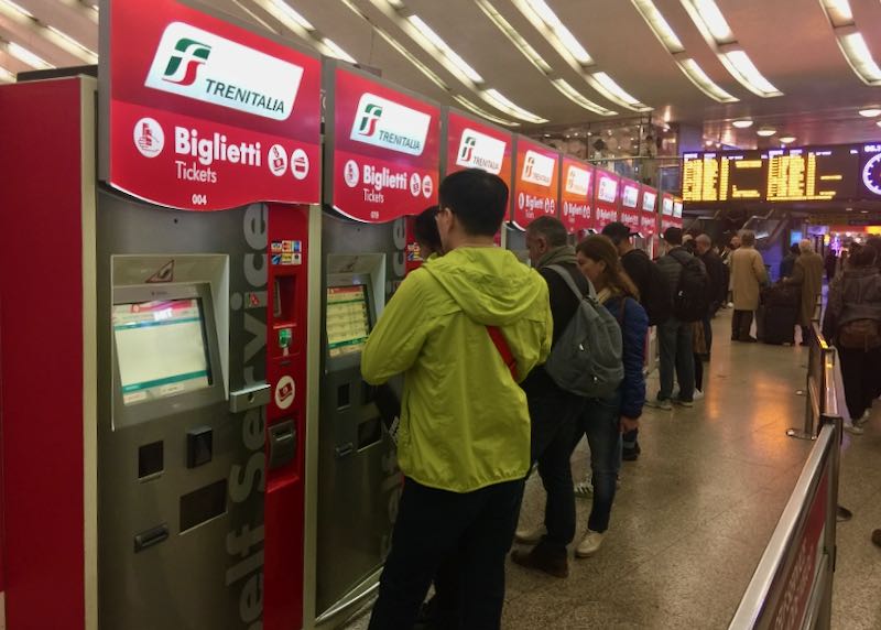 Travelers using self-serve ticket kiosks at Roma Termini station