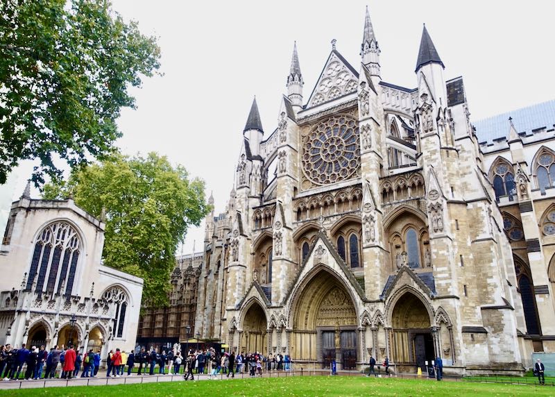 The exterior of Westminster Abbey, with a crowd of visitors waiting to enter